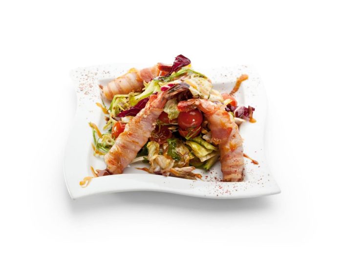 Cigalas con abrigo de bacon y verduras salteadas