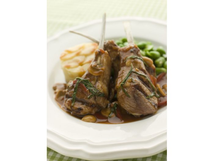 Costillas de cordero asadas acompañadas con habas baby