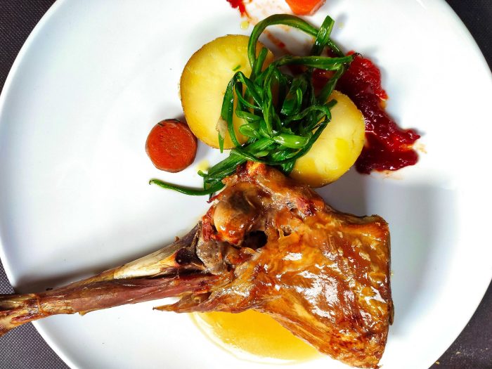 Cuarto de cabrito lechal asado con patatas y verduras
