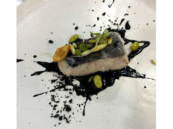 Carbonero al pil-pil con tierra de aceituna, aceite de cebollino con edamame y setas salteadas